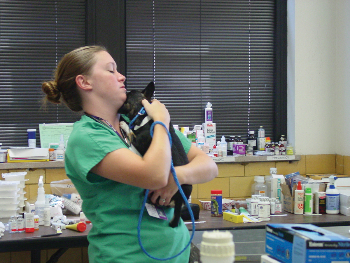 Piper Lombard with a dog in the triage area of Parker Coliseum